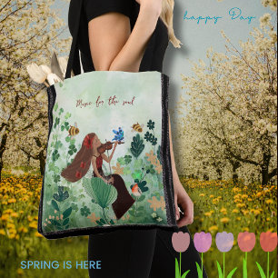 Women in meadow playing a violin tote bag