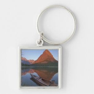 Wooden kayak in Swiftcurrent Lake at sunrise in Key Ring