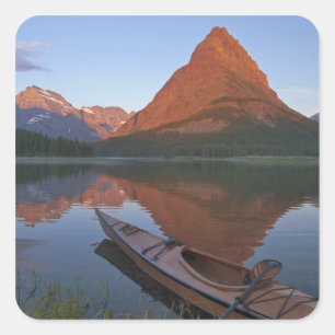 Wooden kayak in Swiftcurrent Lake at sunrise in Square Sticker