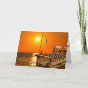 wooden swing with sunset over lake scene card
