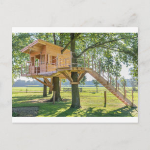 Wooden tree house in oak tree with grass postcard