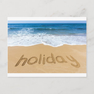 Word holiday written in sand on beach postcard