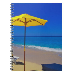 Yellow beach umbrella and chairs on pristine notebook
