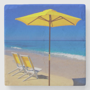 Yellow beach umbrella and chairs on pristine stone coaster