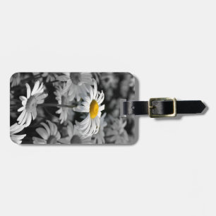 Yellow daisy in a sea of black and white daisies. luggage tag