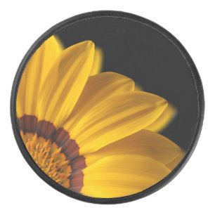 Yellow flower on black background hockey puck