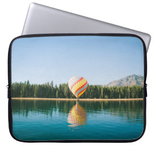 Yellow, red, and blue hot air balloon near trees a laptop sleeve
