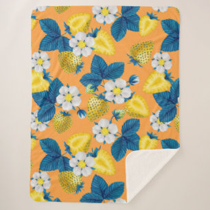 Yellow strawberries on orange sherpa blanket