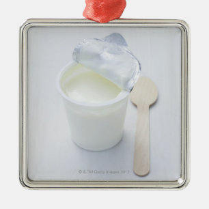Yoghurt in opened disposable cup metal tree decoration