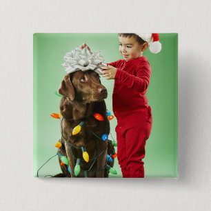 Young boy wrapping Christmas lights around a dog 15 Cm Square Badge