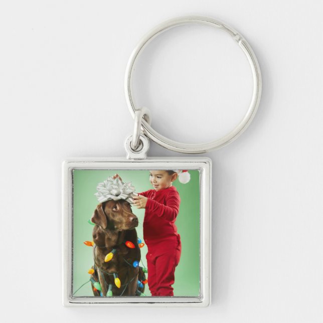 Young boy wrapping Christmas lights around a dog Key Ring (Front)
