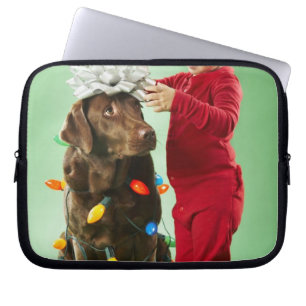 Young boy wrapping Christmas lights around a dog Laptop Sleeve