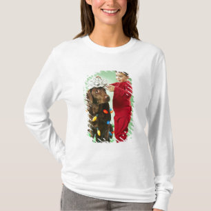 Young boy wrapping Christmas lights around a dog T-Shirt