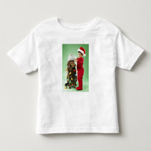 Young boy wrapping Christmas lights around a dog Toddler T-Shirt