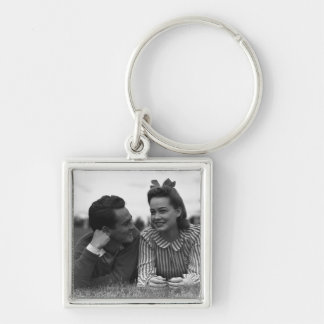 Young couple lying on grass key ring
