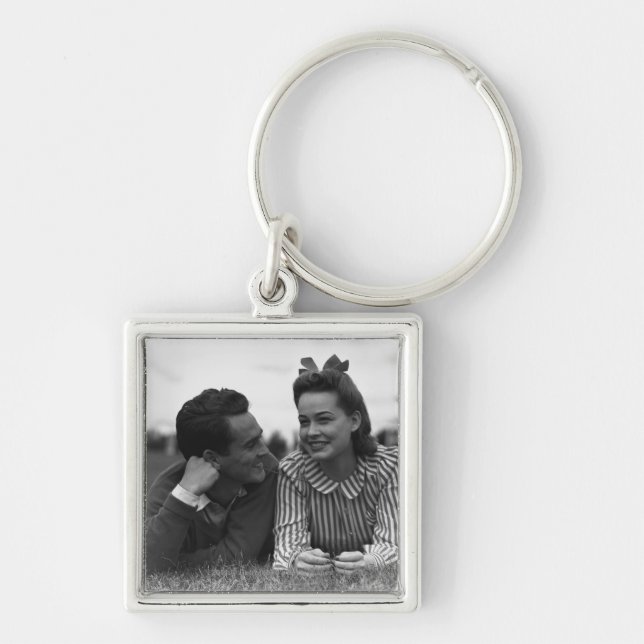 Young couple lying on grass key ring (Front)