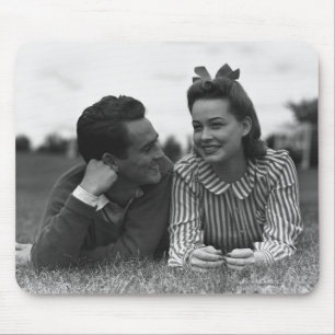 Young couple lying on grass mouse mat