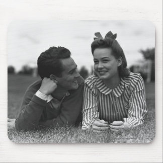 Young couple lying on grass mouse mat