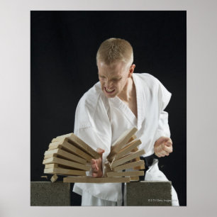 Young man breaking boards with karate chop on poster
