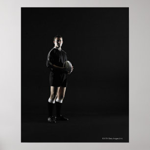 Young man holding rugby ball, portrait poster
