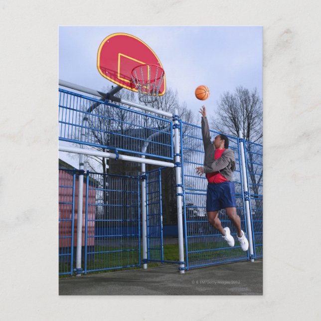 Young man playing basketball outdoors postcard (Front)