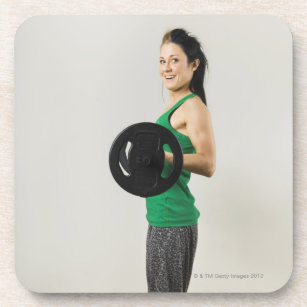 Young woman lifting a barbell. coaster
