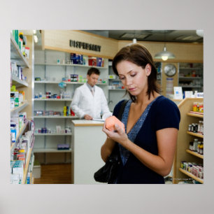 Young woman looking at medicine in pharmacy, poster