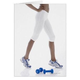 Young woman with dumbbells stretching (low