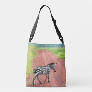 Zebra walking over the road. Africa, Serengeti Crossbody Bag